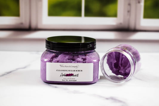 Purple sugar scrub jar with a visible brand label on a white surface.