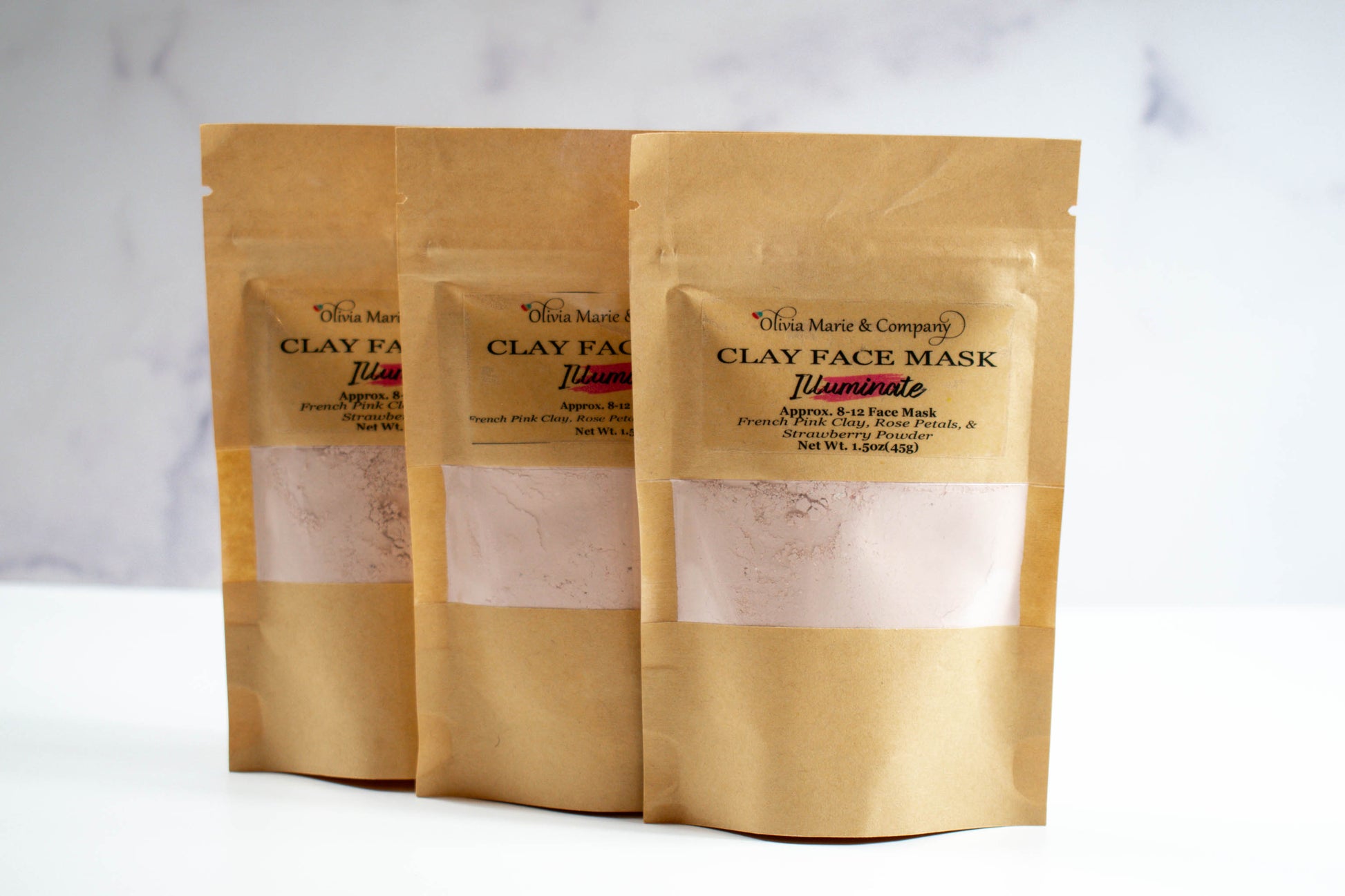 Pink clay face mask in brown bag with clear window.