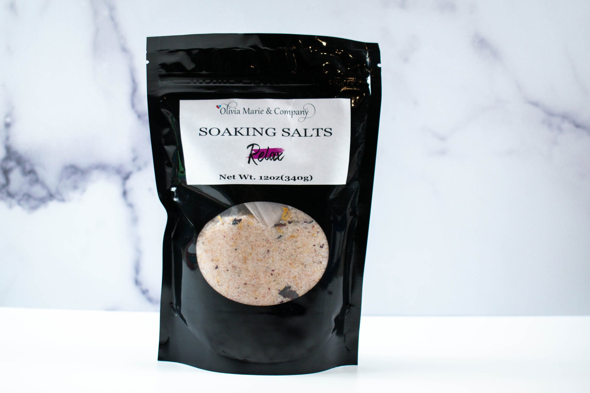Relax Soaking Salts in a black bag with a clear window to show the salts.