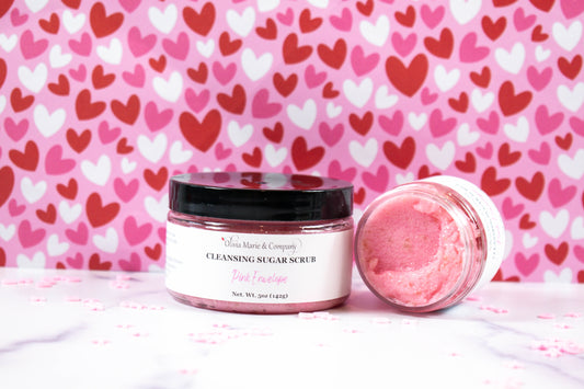 Pink Envelope Sugar scrub with hearts in the background. 